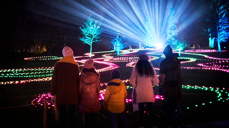 A family looking out at one of the Christmas at Stourhead installations for 2025